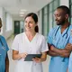 International nurses from Kenya and Cameroon collaborate with German colleagues in a modern hospital setting.